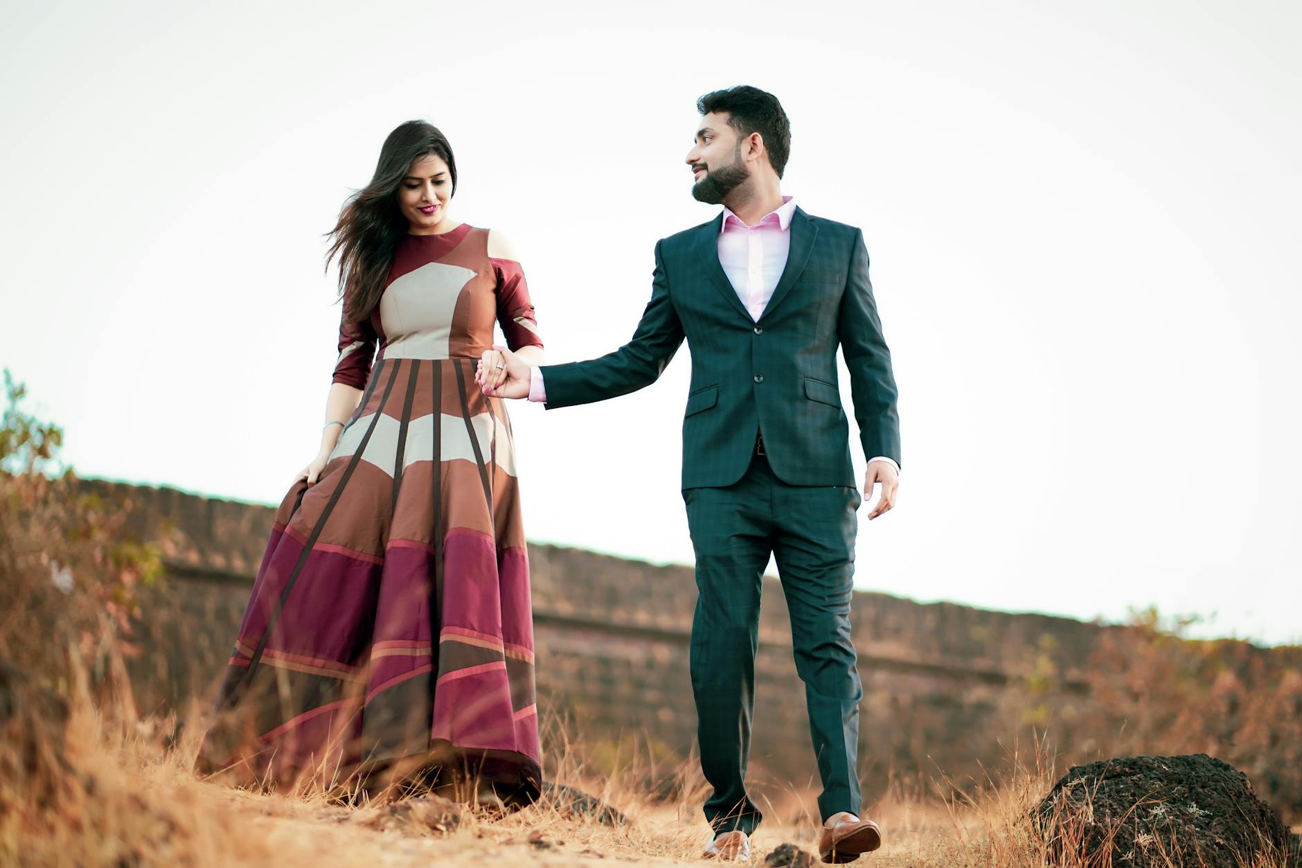 photo of coupe walking on grass field